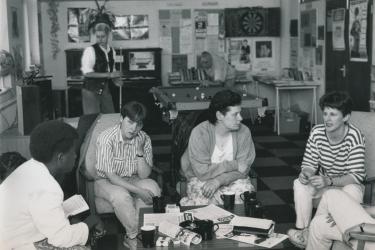 Lesbian group meeting at the Greenwich Lesbian and Gay Centre with people sitting around a coffee table and playing pool