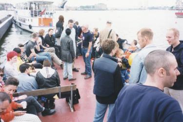 Groups of people talking on the Pride Boat from Greenwich to Westminster in 1998