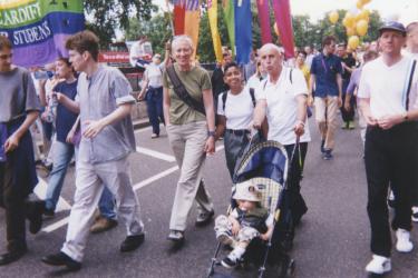 Three Metro Centre Pride participants featured as marchers in the parade with a child in a pushchair. 