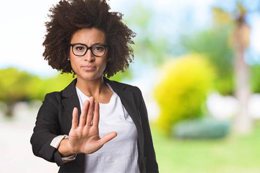 Women holding up hand to gesture stop