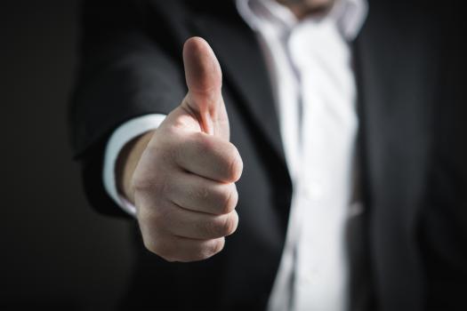 Man in a suit doing a thumbs up gesture