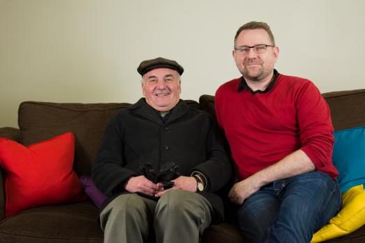 Norman sitting on the sofa with a person from our 50+ social group