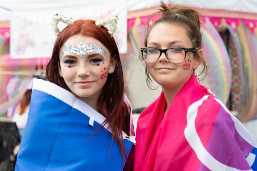 Two young people wearing bisexual flags at Essex Pride