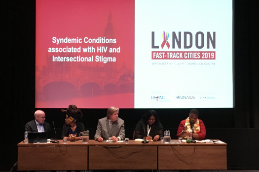 Panel of five in front of title slide, 'Syndemic conditions associated with HIV and Intersectional Stigma