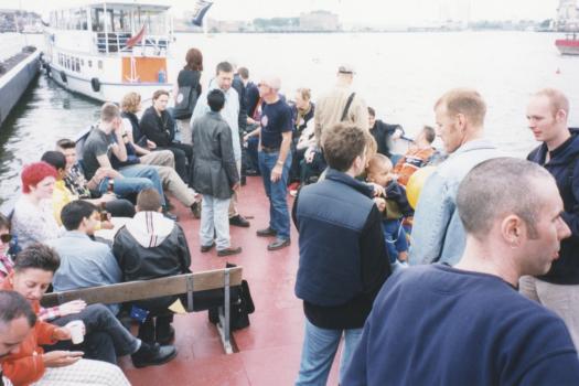 Groups of people talking on the Pride Boat from Greenwich to Westminster in 1998