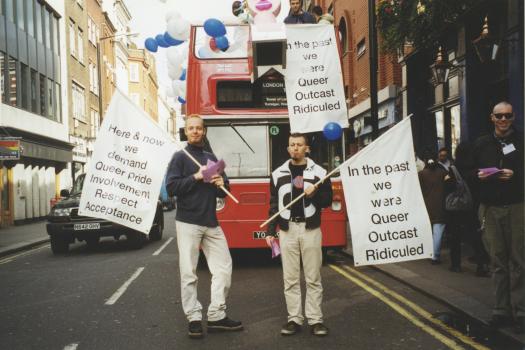 Two men standing in front of a red London Bus decked out for The Metro Centre's Ship of Fools-themed participation in World Mental Health Day, 1998 