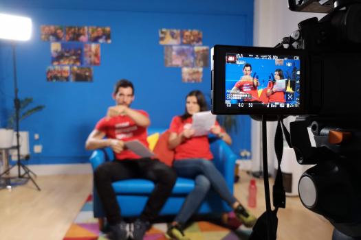 A camera filming two people on a sofa