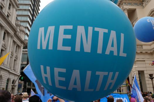 Photo of a very large teal coloured balloon in the street with the words Mental Health written across it