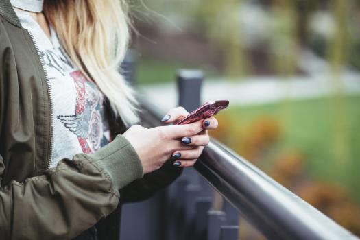 Blonde woman using pink mobile phone