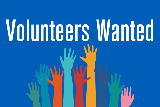 Text saying Volunteers wanted, above a group of raised hands in multiple colours